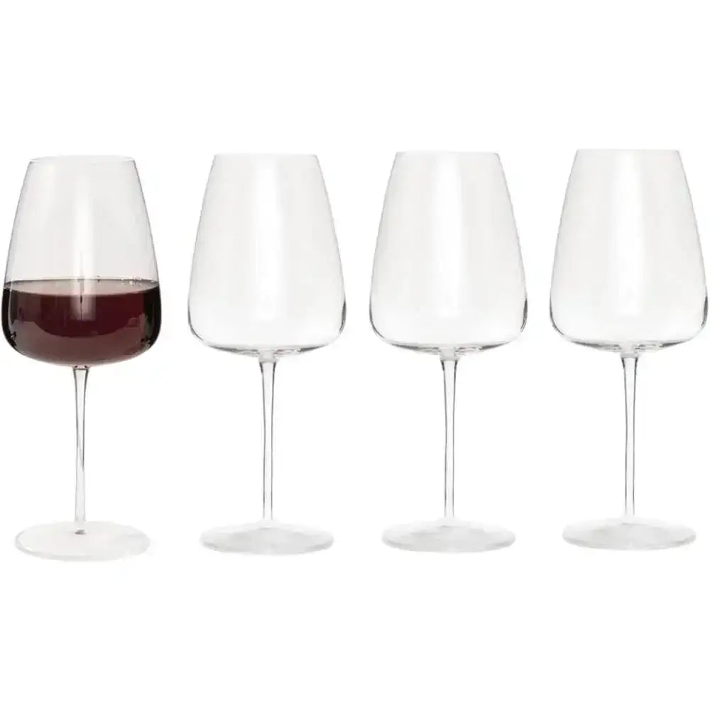 Set of four wine glasses with one containing red wine on a white background