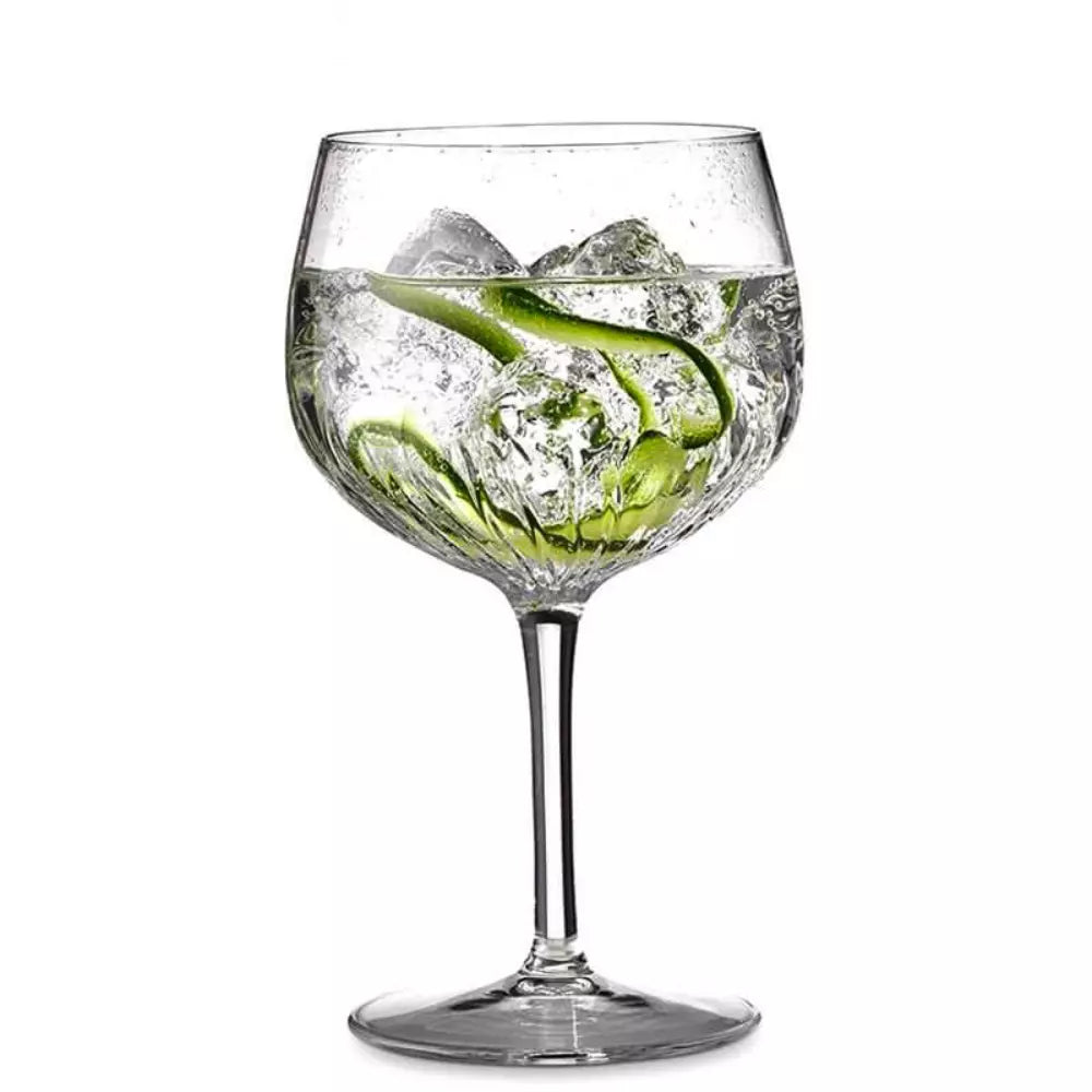 Clear glass with ice cubes and a green straw on a white background