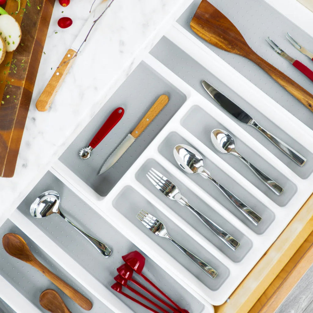 Silverware set with wooden utensils in a drawer organizer on a light background