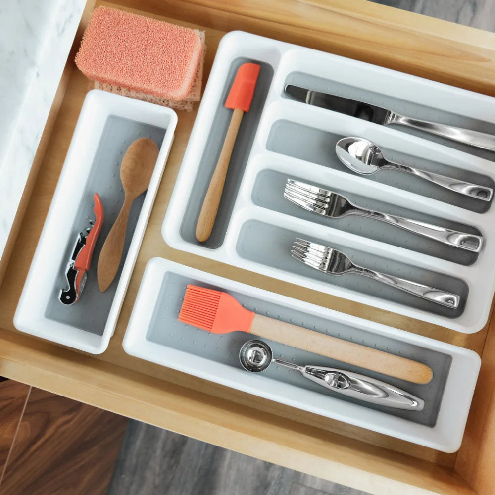 Kitchen utensil organizer with cutlery and tools on a wooden surface