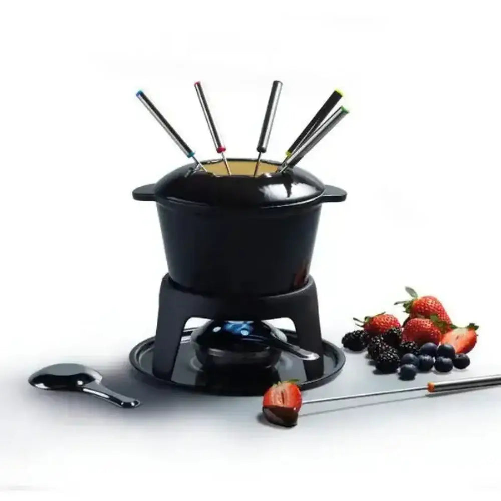 Black fondue set with skewers, fruits, and a spoon on a white background