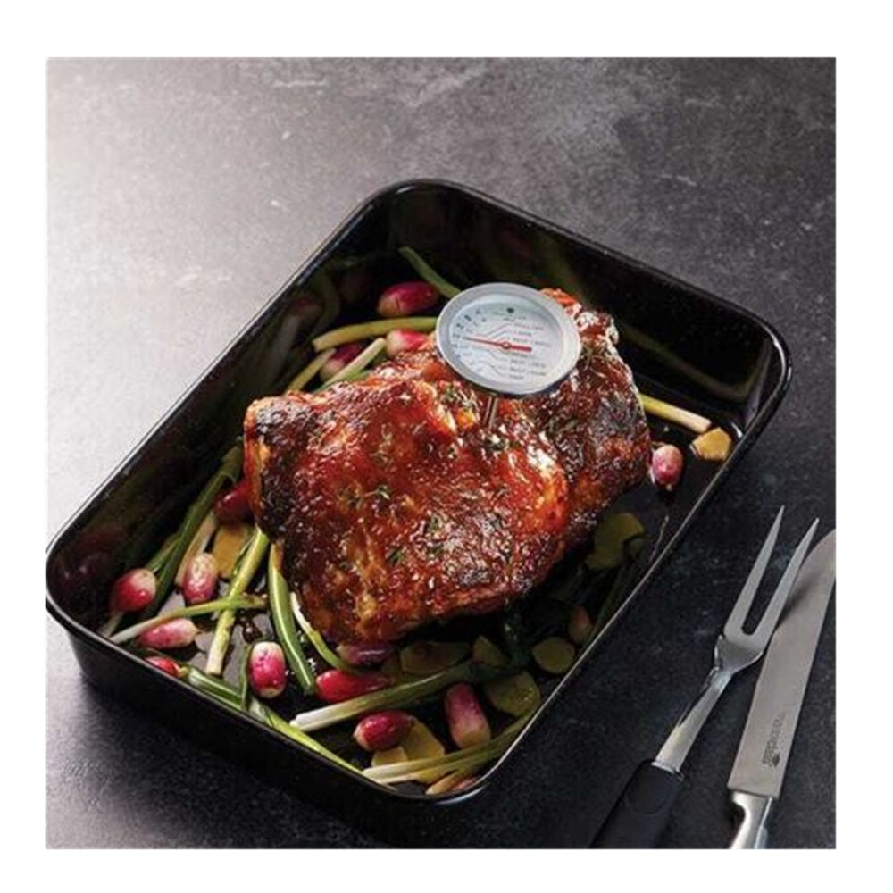 Roasted meat with vegetables on a black tray, featuring a meat thermometer.