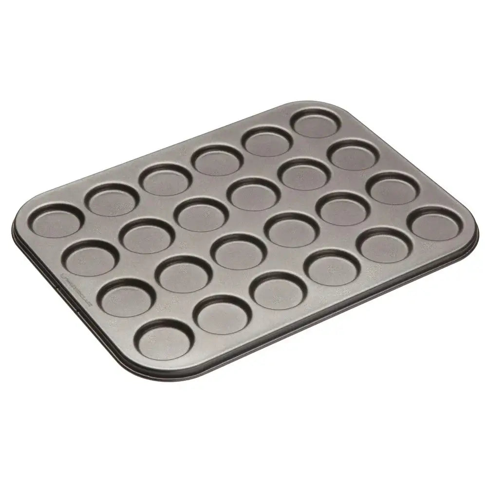 Metal muffin tin with 24 small round cavities on a white background