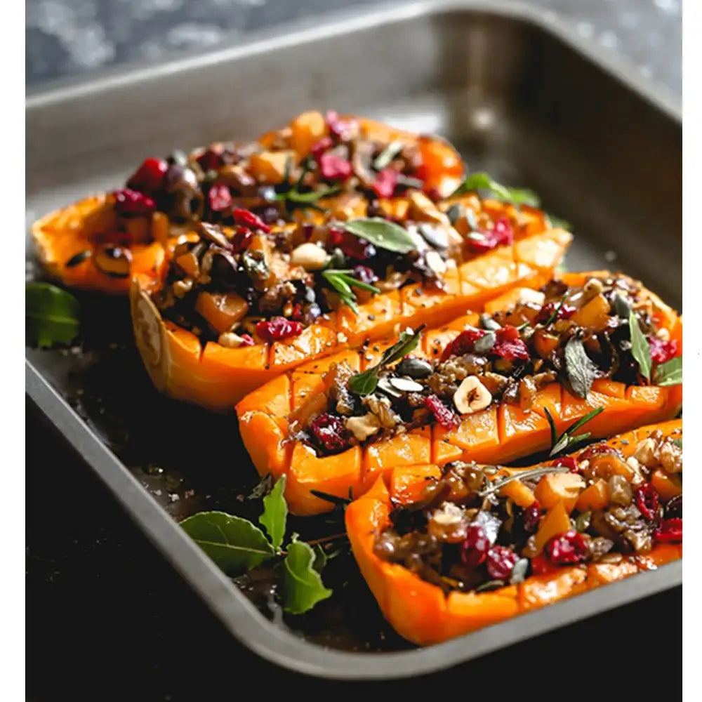 Stuffed butternut squash on a baking tray with herbs and nuts