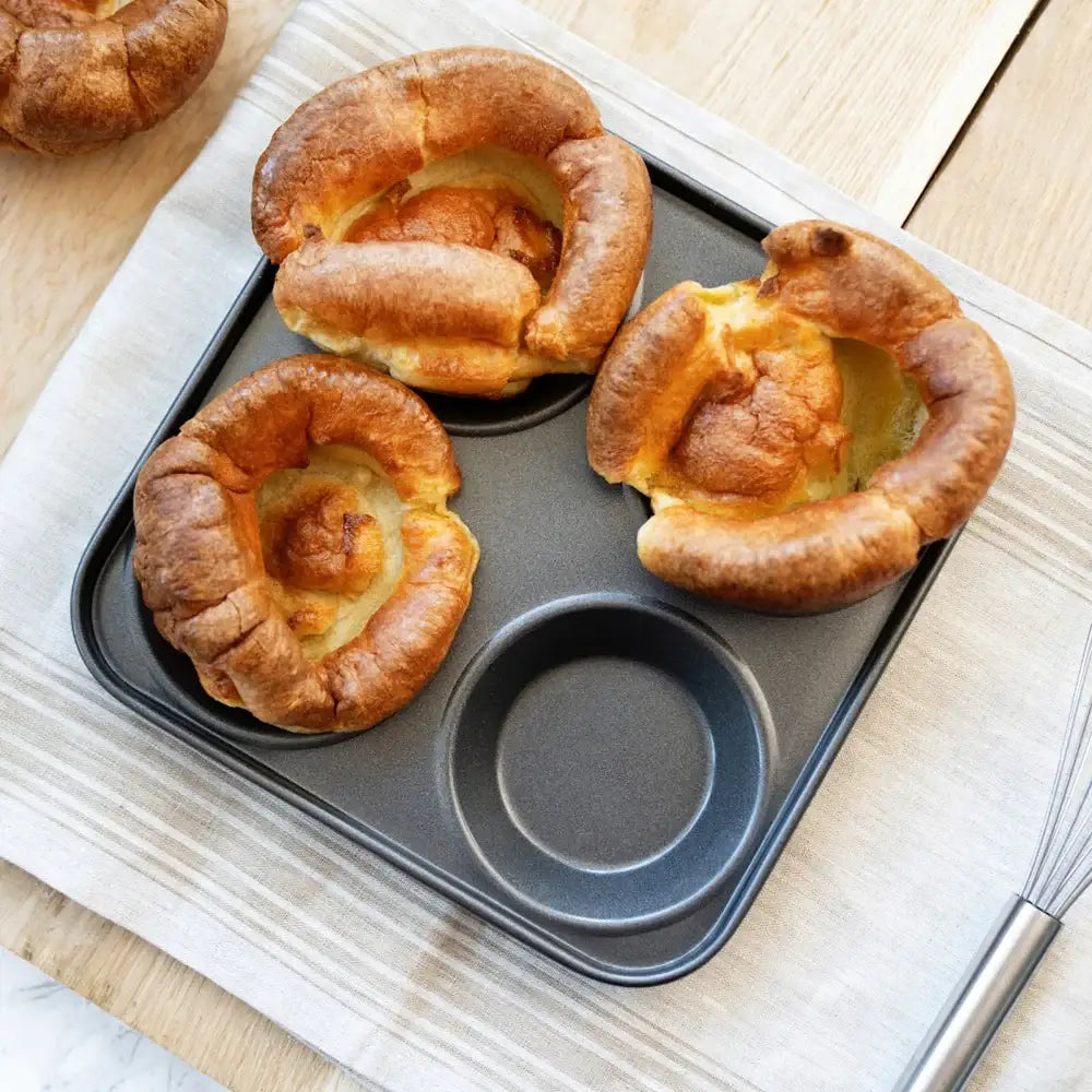 Yorkshire puddings in a baking tray on a wooden surface