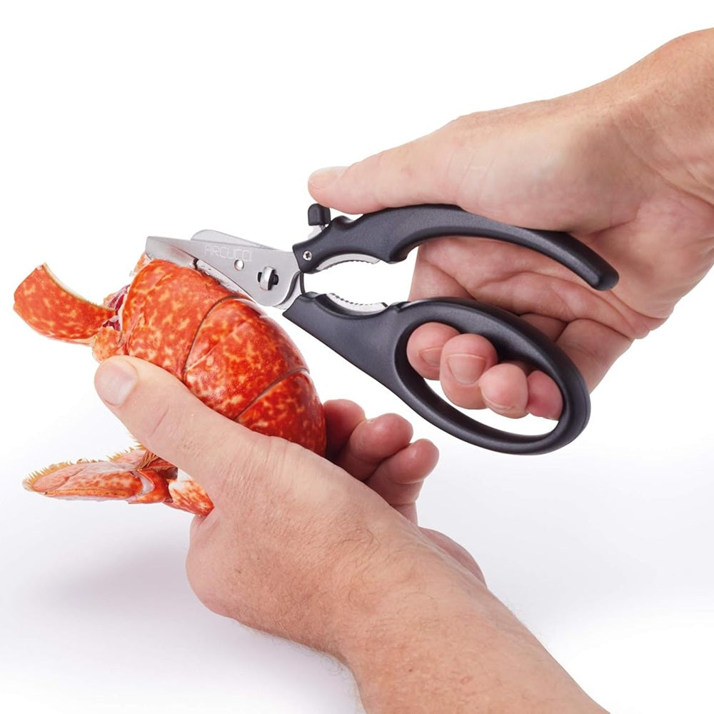 Person using kitchen shears to open a lobster on a white background