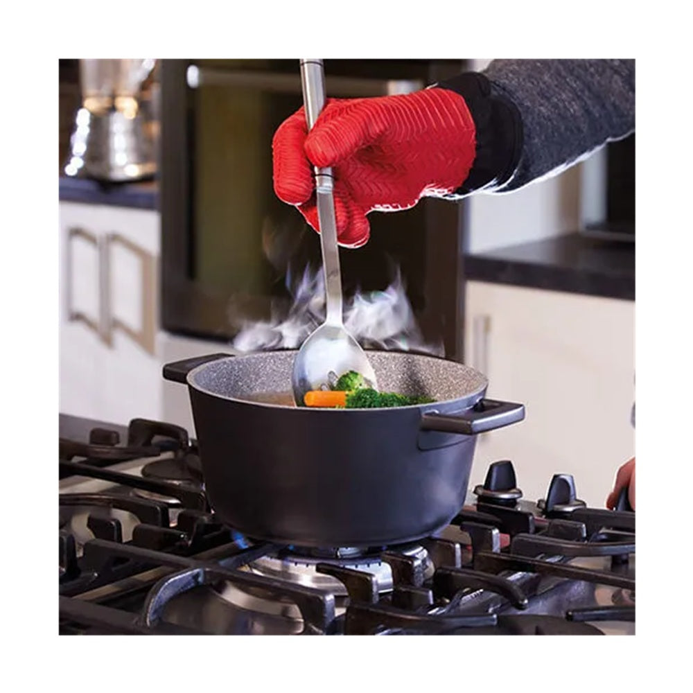 Person wearing a red oven mitt stirring vegetables in a pot on a stove