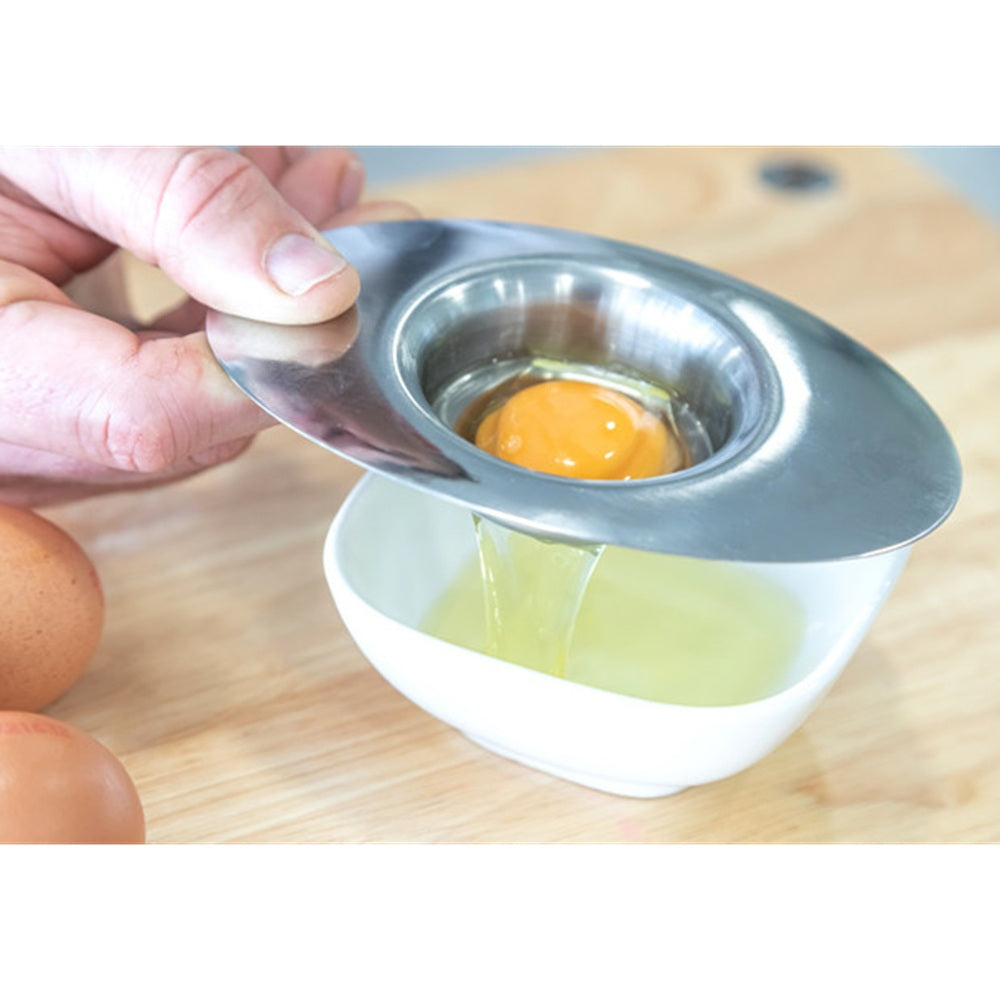 Person using an egg separator on a wooden surface
