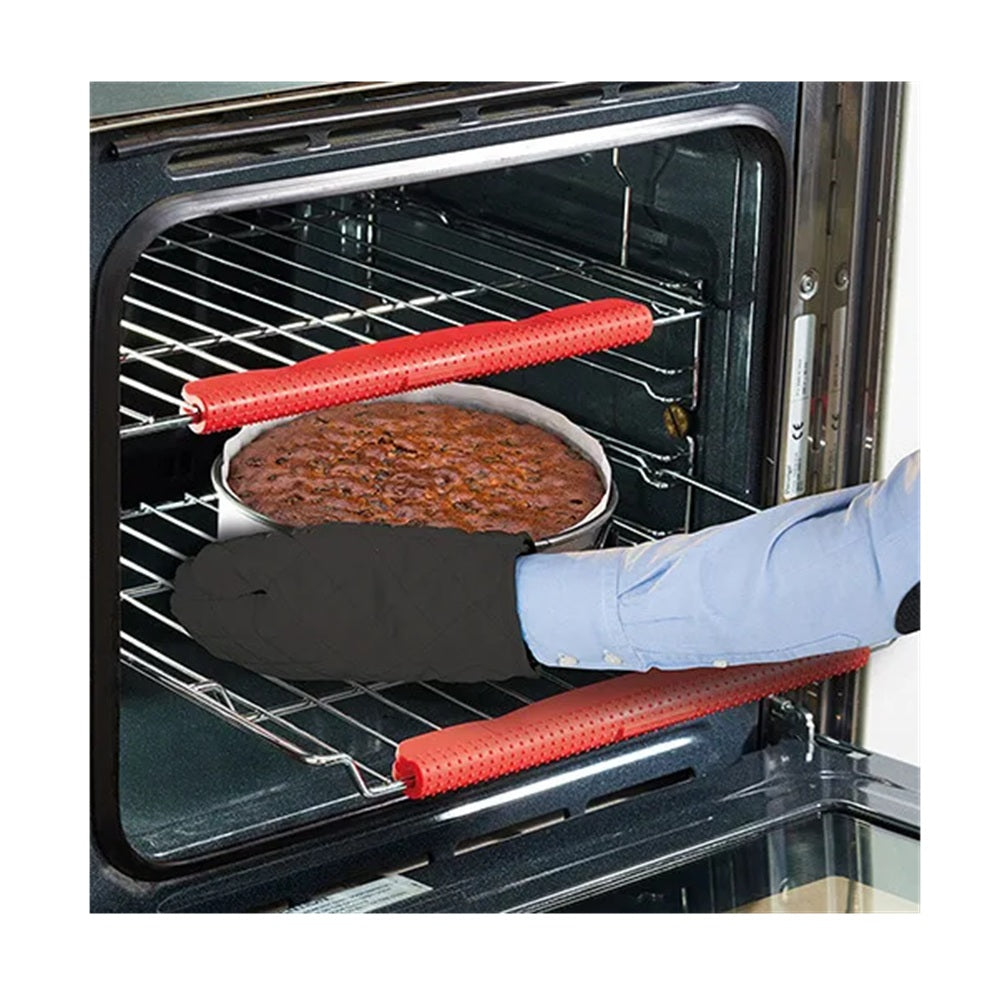 Person using red oven mitts to remove a dish from an open oven