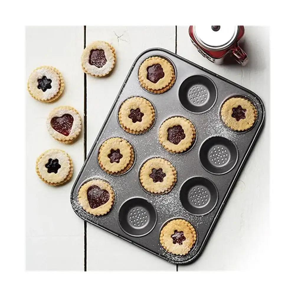 Baking tray with linzer cookies on a white surface