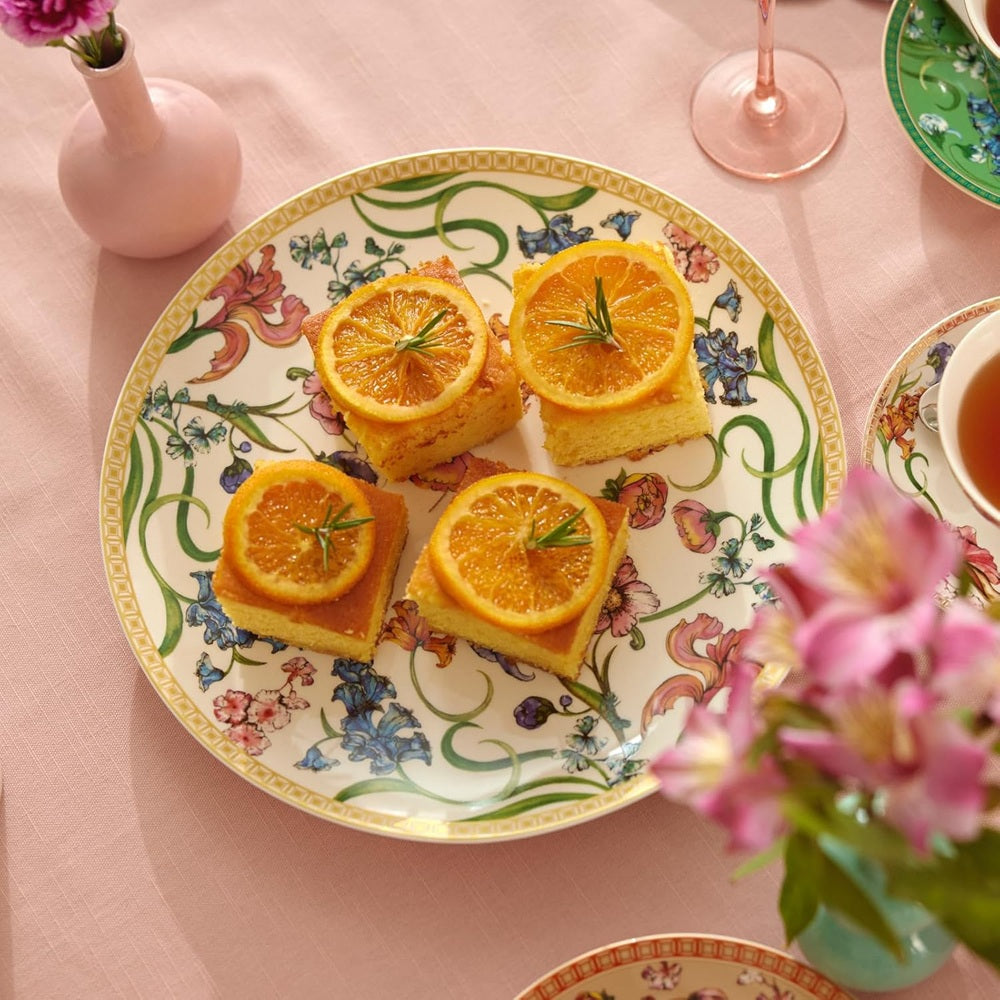 Decorative plate with orange slices on a pink tablecloth