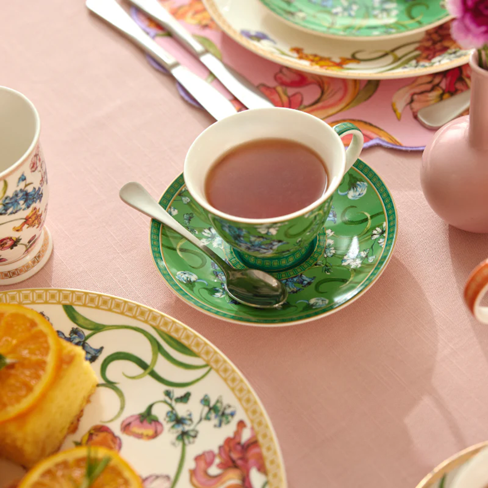 Tea cup and saucer with floral design on a pink tablecloth