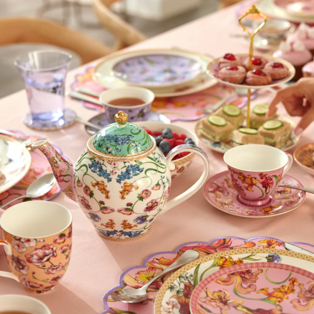 Decorative tea set with teapot, cups, and plates on a table.