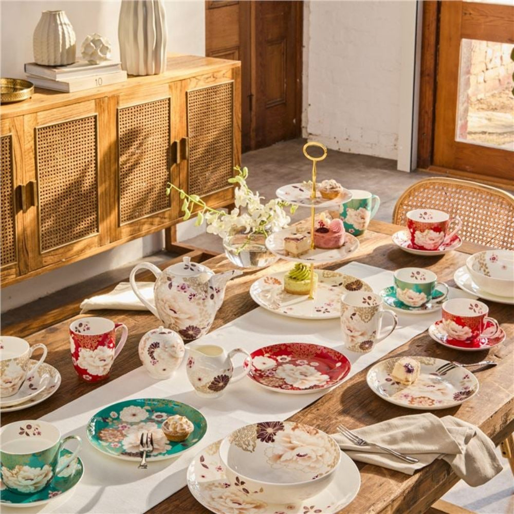 Tea set on a wooden table with floral patterns in a cozy room.