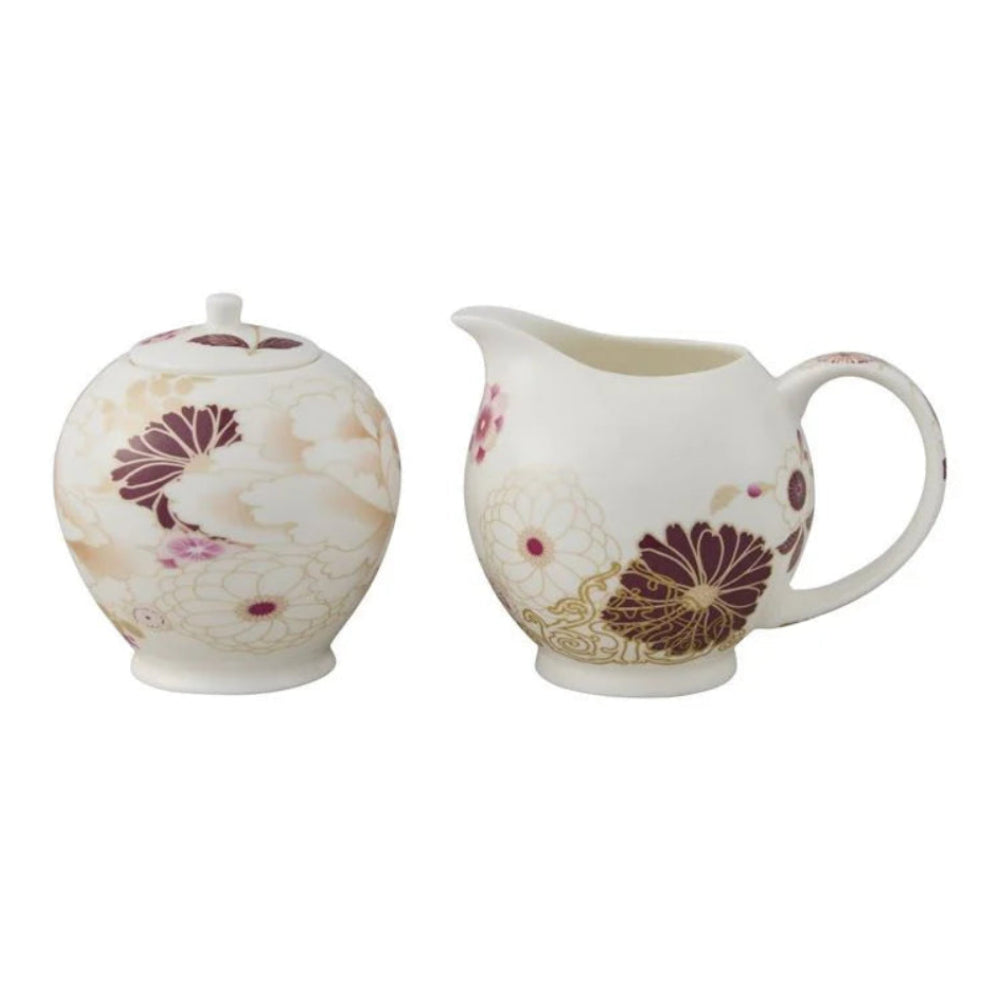 Tea pot and creamer set with floral design on a white background