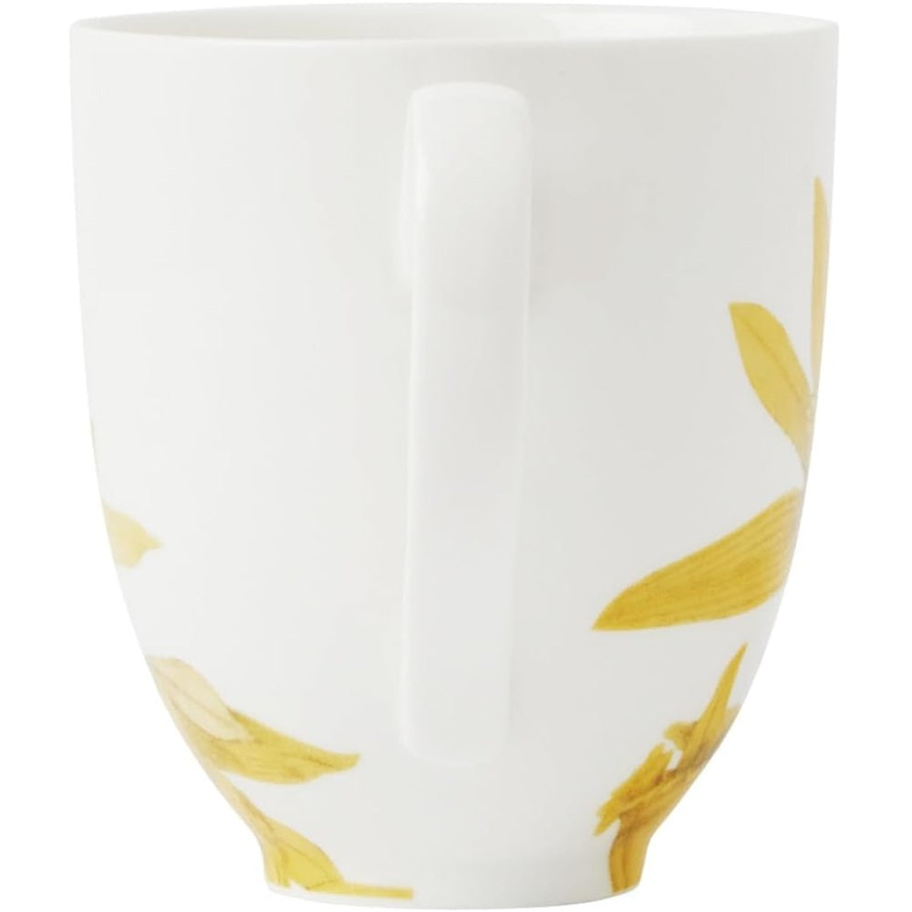 White mug with yellow leaf patterns on a white background