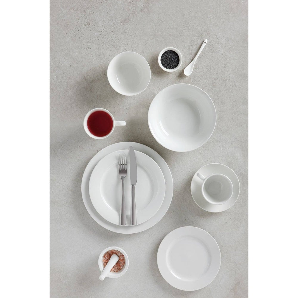 White ceramic dinnerware set on a gray surface with small bowls and a cup.