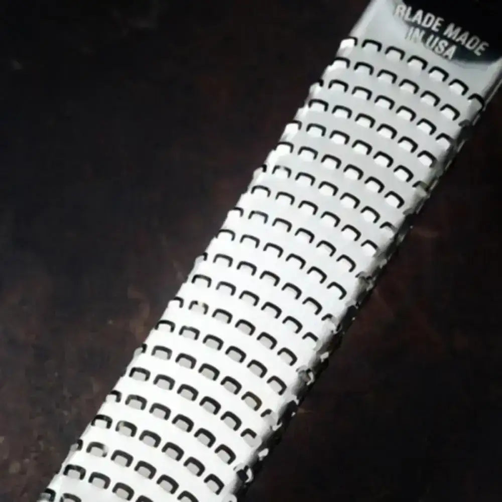 Close-up of a metal blade with 'Made in USA' text on a dark background