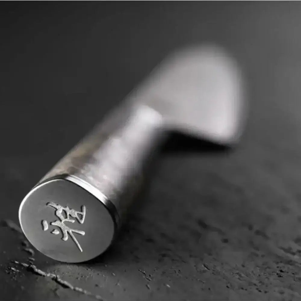 Metallic tool with engraved characters on a dark surface