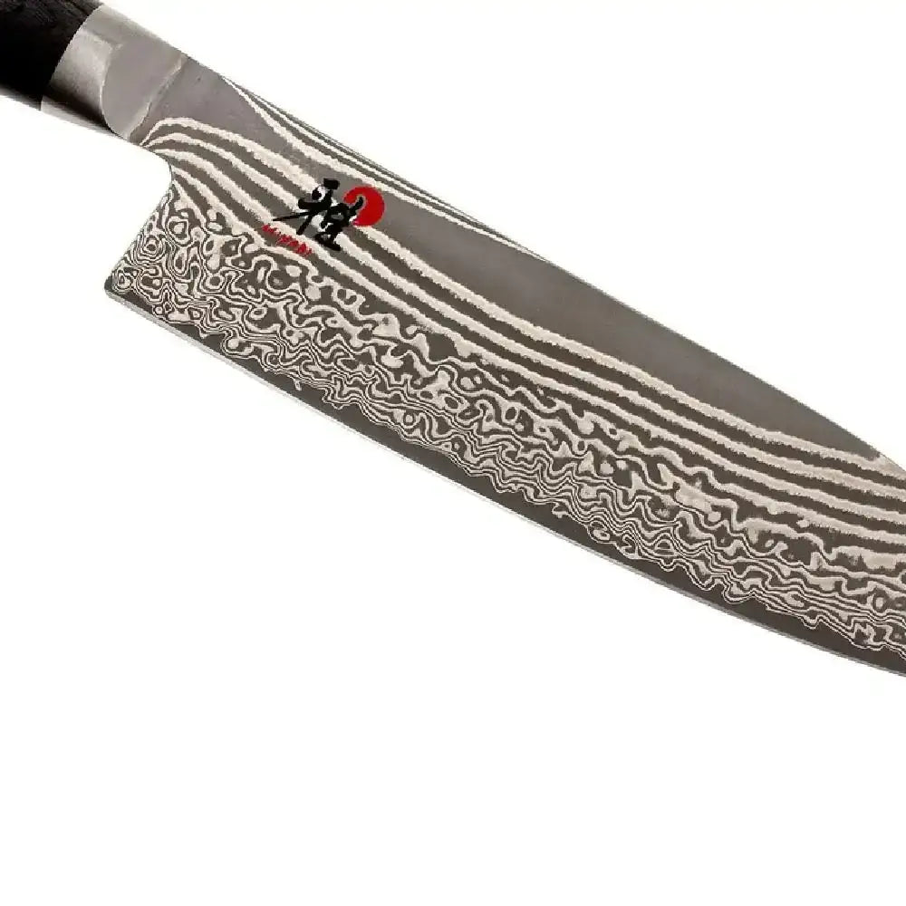 Damascus-patterned knife blade on a white background