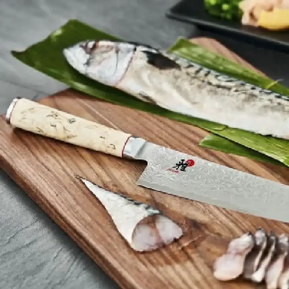 Sashimi knife on a wooden cutting board with fish and wasabi