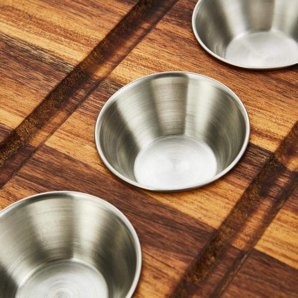 Three stainless steel bowls on a wooden surface