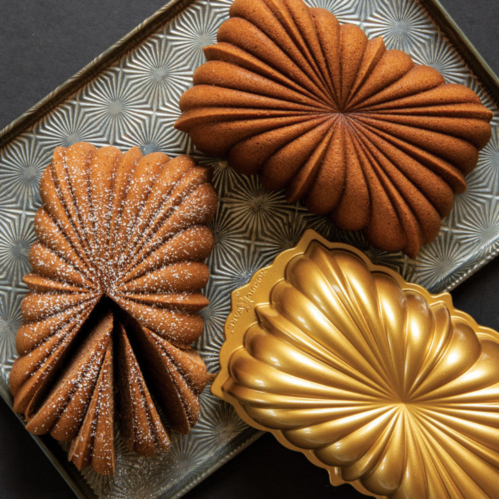 Three shell-shaped pastries on a decorative tray with a geometric pattern.