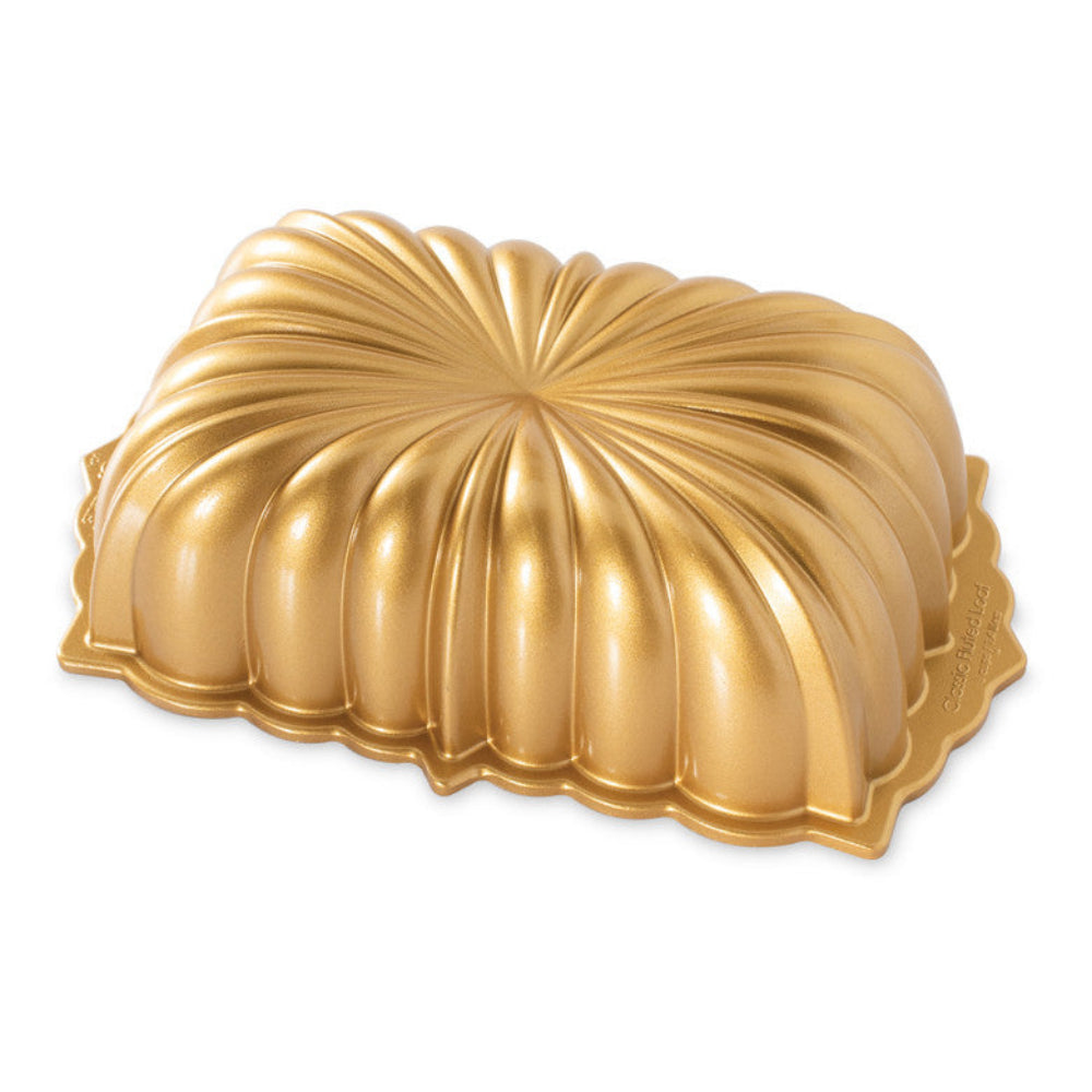Gold Nordic Ware Bundt cake mold on a white background