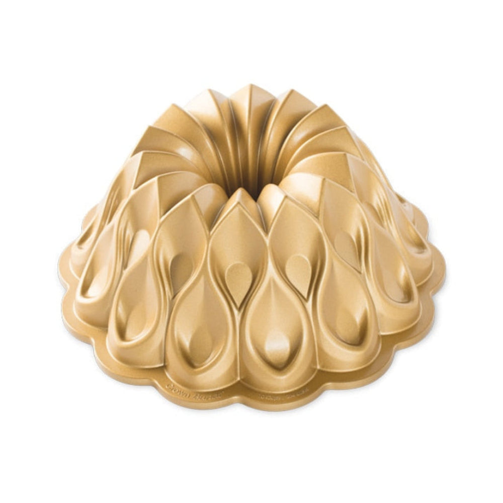 Gold-colored Nordic Ware Bundt cake pan with a unique teardrop-shaped pattern, shown on a solid white background.