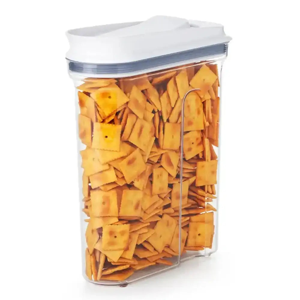 Clear container with white lid filled with crackers on a white background