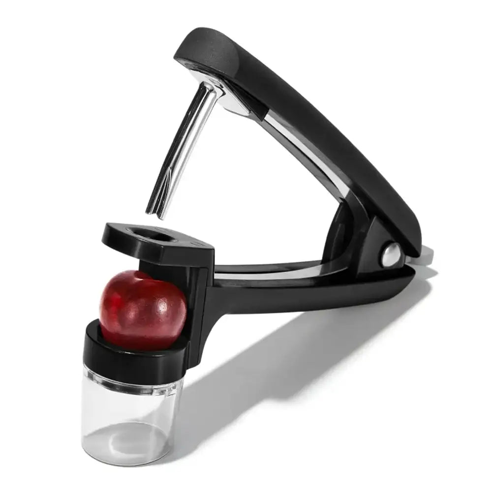 Black pitter tool with a cherry on a white background