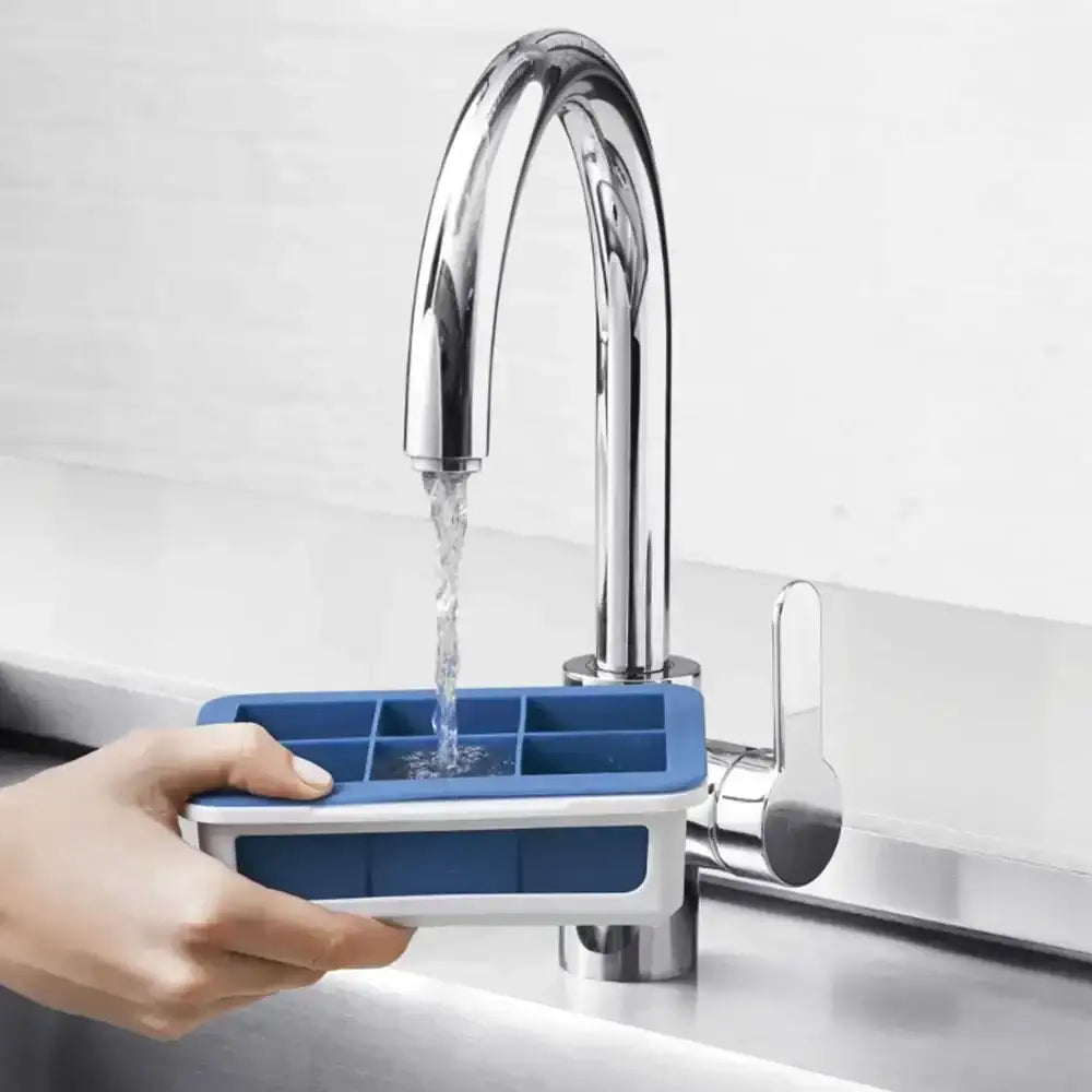 Blue ice cube tray being filled with water from a faucet in a kitchen setting.