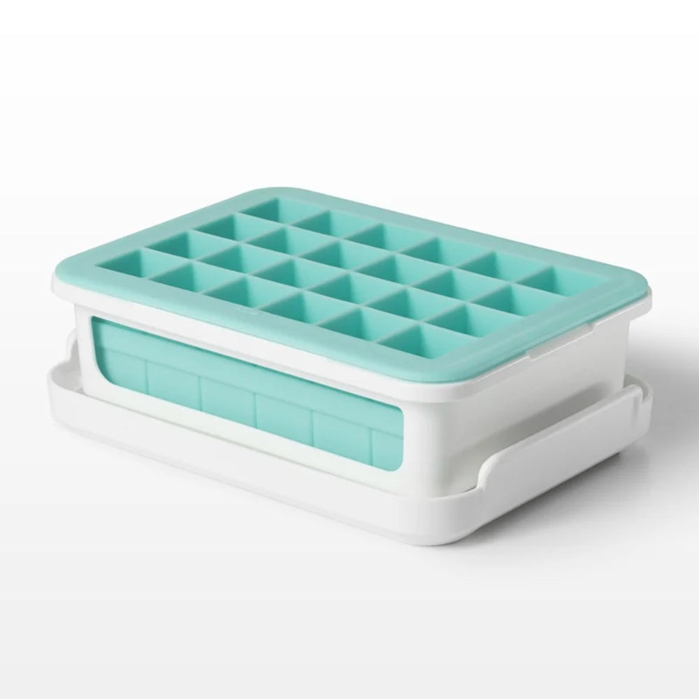 Turquoise ice cube tray with white base on a white background