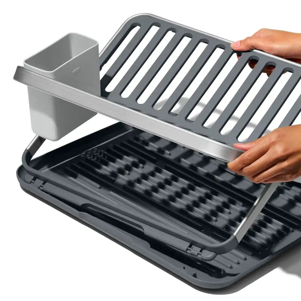 Gray dish rack with a hand lifting the lid on a white background