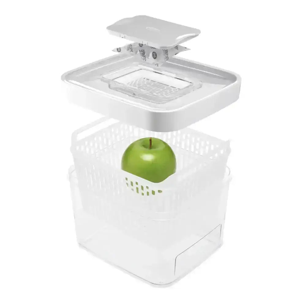 White food storage container with a green apple inside on a white background