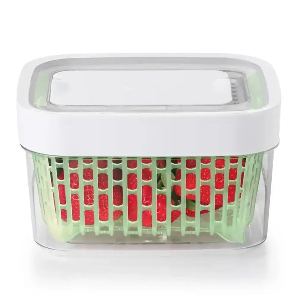 Clear container with green lid holding red gummy bears on a white background