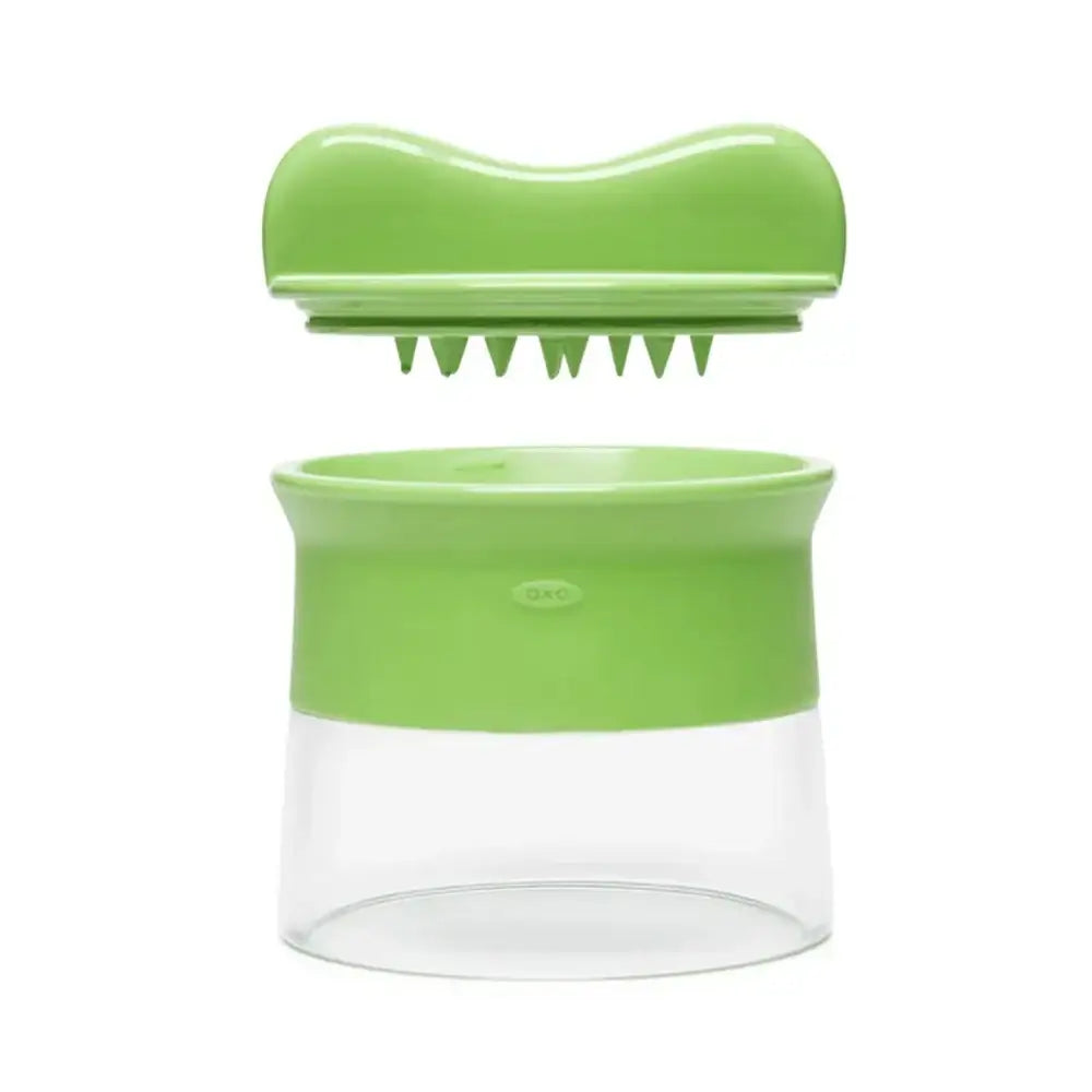 Green kitchen tool with a clear container on a white background