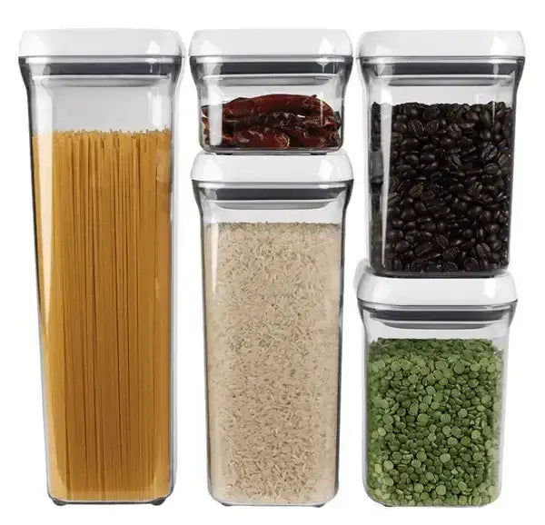 Set of four clear storage containers with lids, each filled with different types of dry goods.