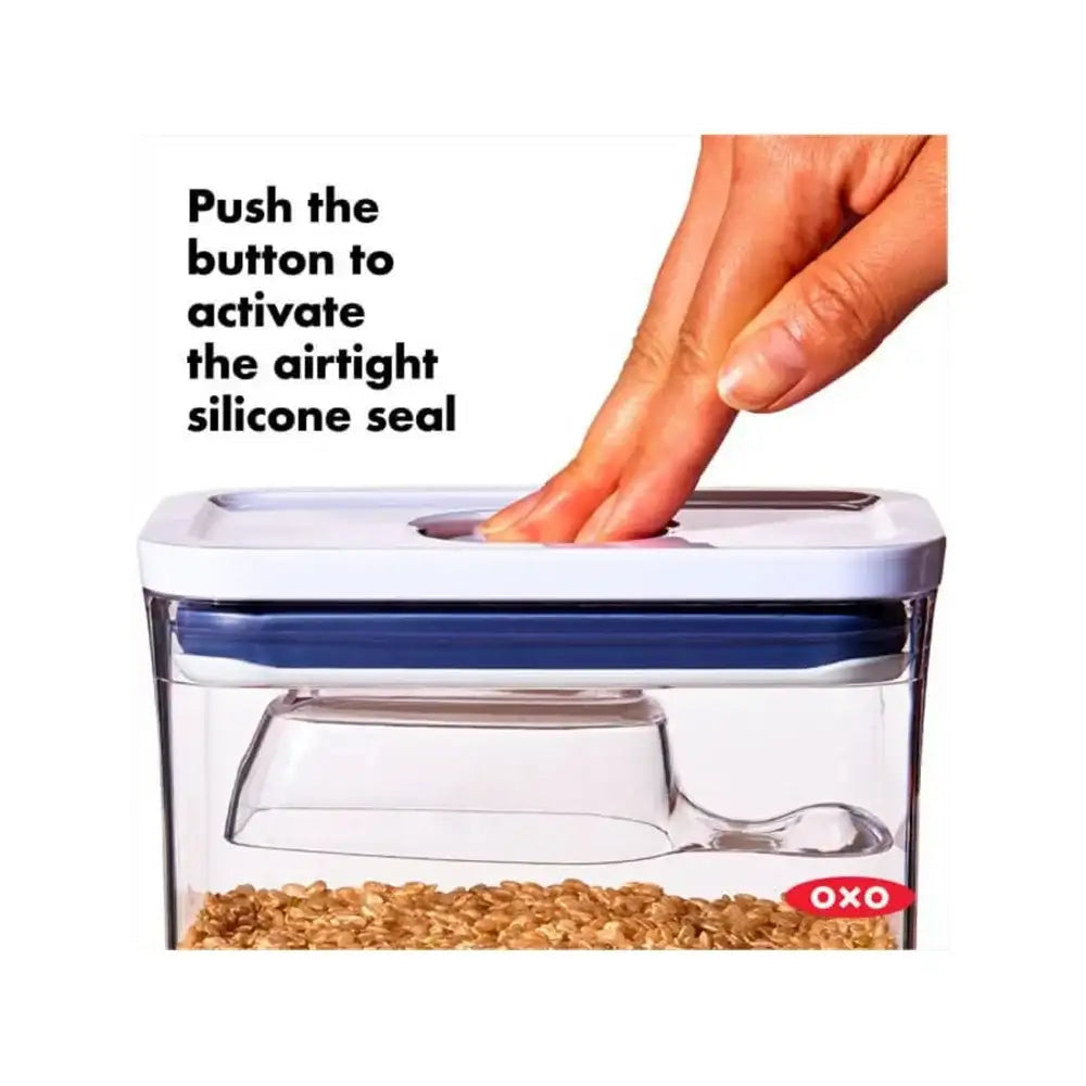 OXO food storage container with a hand pushing a button to activate an airtight silicone seal.