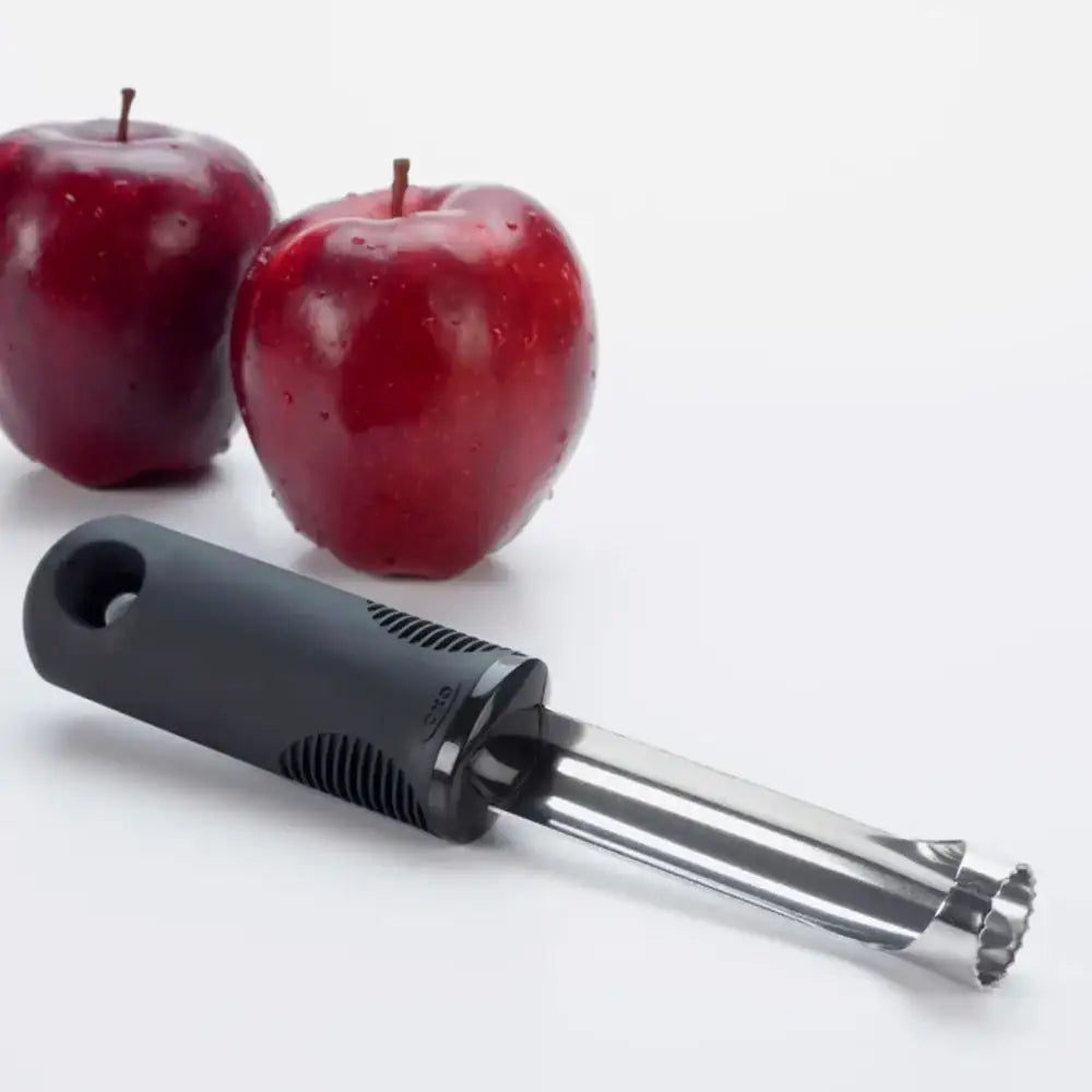 Apple corer with two red apples on a white background