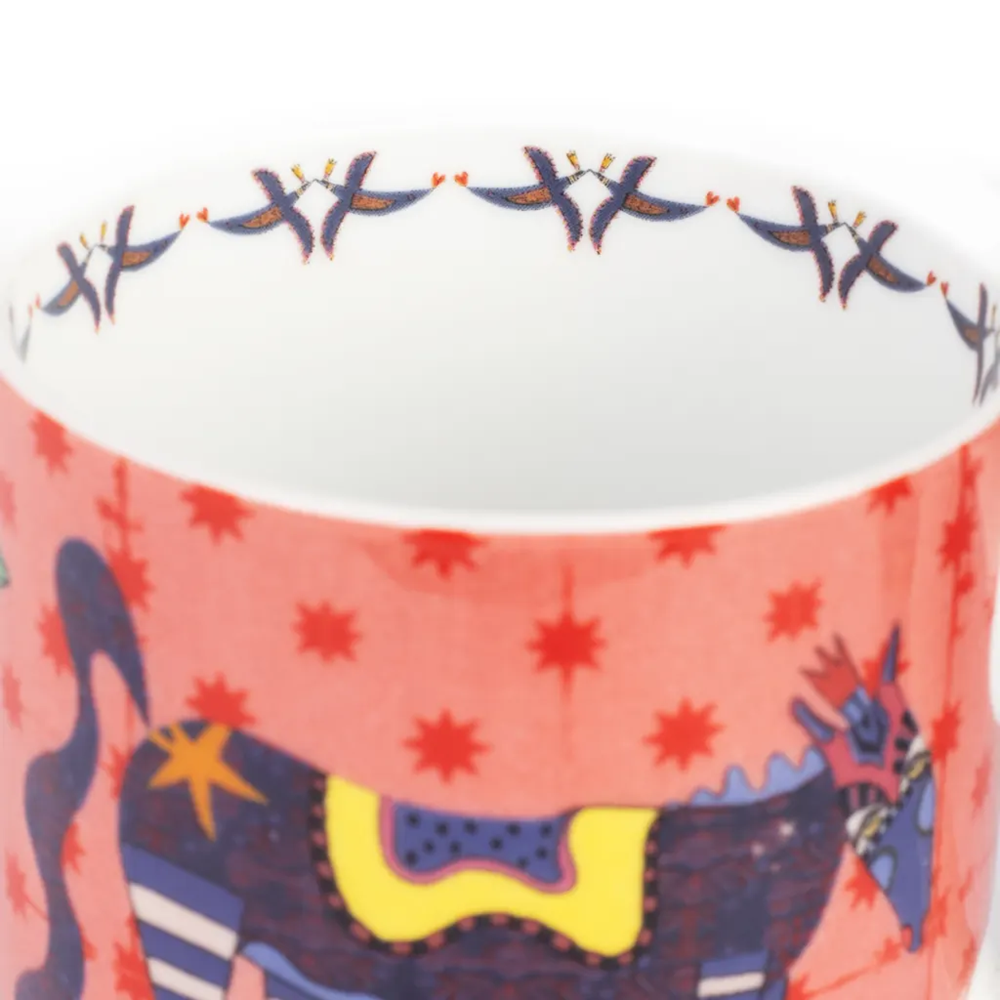 Ceramic mug with colorful animal design and star pattern on a white background