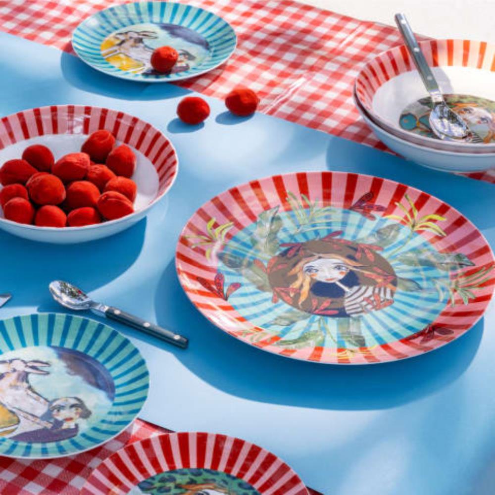 Colorful ceramic plates with artistic designs on a checkered tablecloth.
