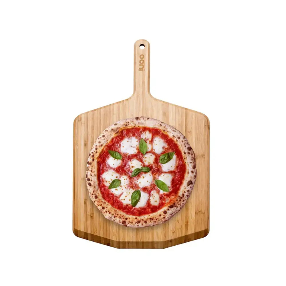 Wooden pizza peel with a pizza on a white background