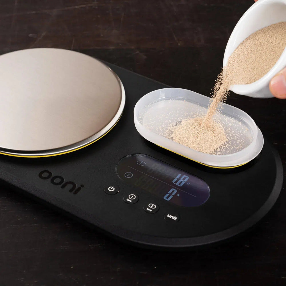 Person pouring yeast onto a digital scale 