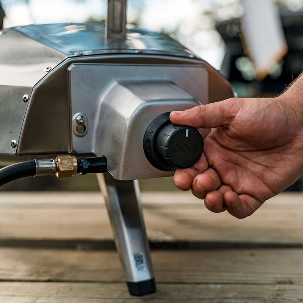 Hand adjusting a knob on a metallic device with a blurred background