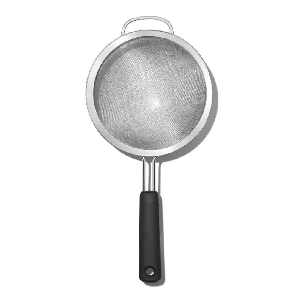 Metal strainer with black handle on a white background