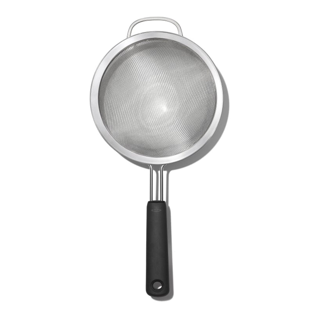 Metal strainer with black handle on a white background
