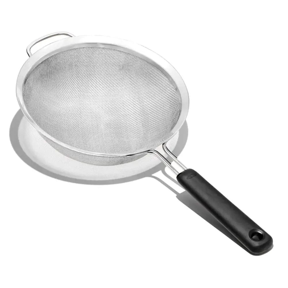Metal strainer with a black handle on a white background