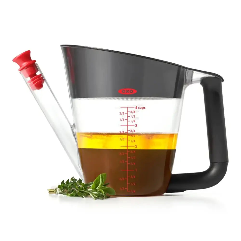 Measuring cup with oil and herbs on a white background