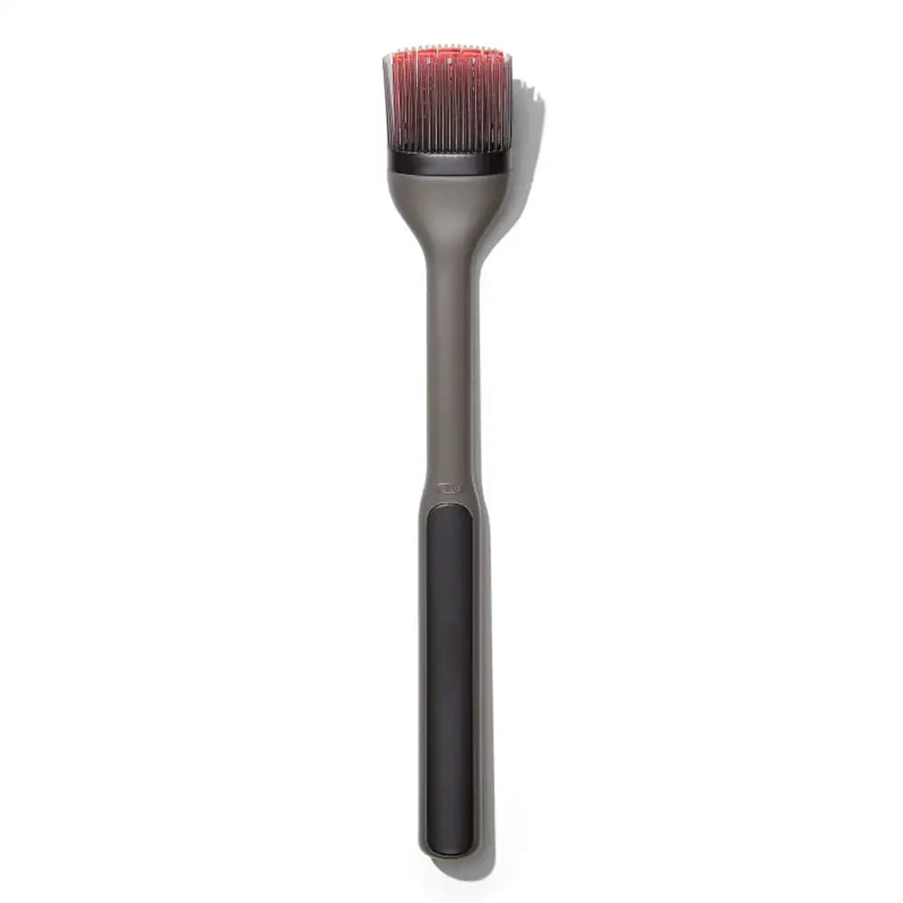 Barbecue brush with red bristle head on a white background